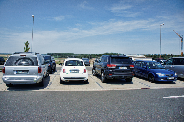 Photograph of 2013 Fiat Pop parked between two larger cars in Germany.